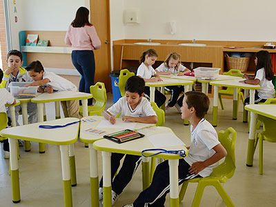 Alumnos trabajando en el aula con su maestra